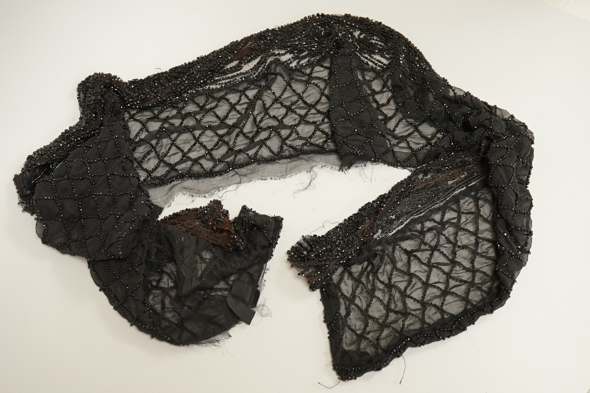 A cut steel fronter, a jet beaded panel, a pair of fringed black suede gauntlets, a seed pearl headdress, etc.